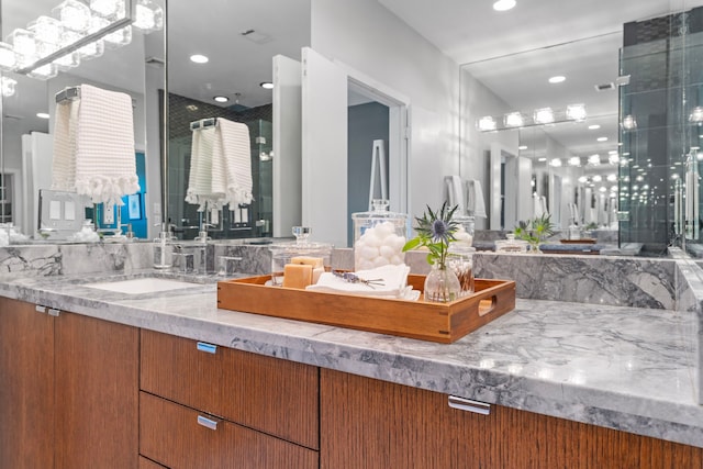 bathroom featuring recessed lighting, a shower with shower door, and vanity