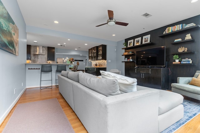 living area with a ceiling fan, baseboards, recessed lighting, wood finished floors, and visible vents