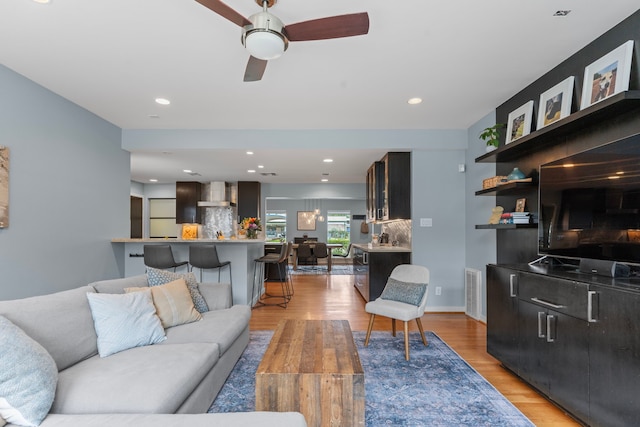 living area featuring recessed lighting, ceiling fan, light wood finished floors, and visible vents
