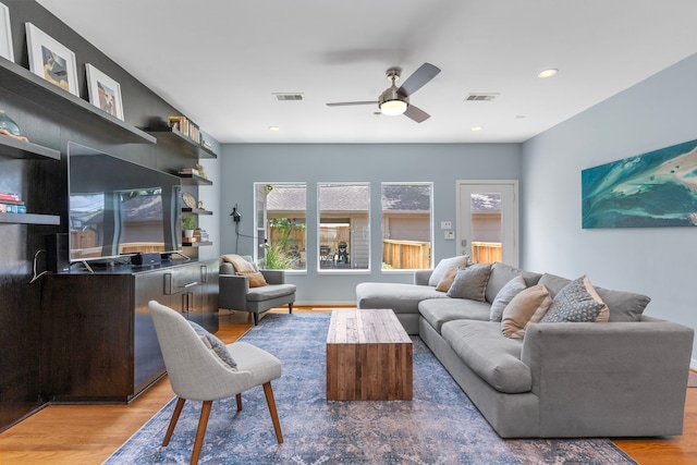 living area featuring visible vents, ceiling fan, and wood finished floors