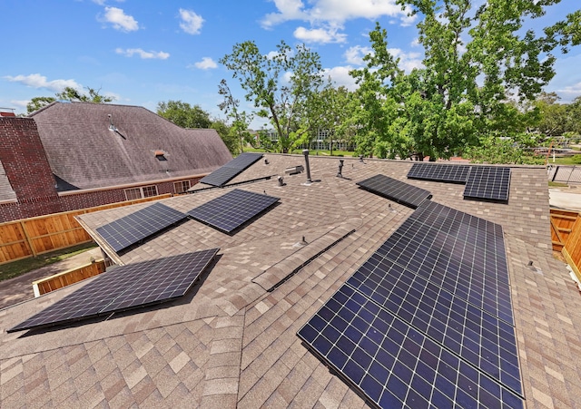 exterior details featuring roof with shingles and fence