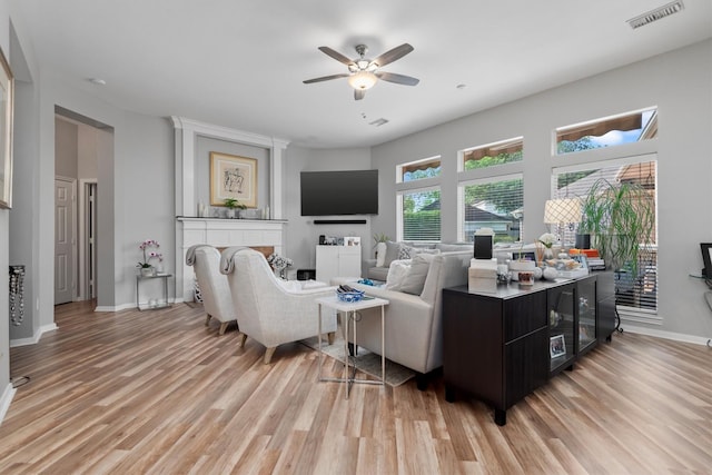 9614 Oconnor Ln, Missouri City, TX 77459 - living room with ceiling fan, a fireplace, baseboards, light wood-type flooring, and visible vents