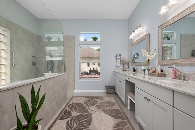 9614 Oconnor Ln, Missouri City, TX 77459 - bathroom with walk in shower, a sink, double vanity, tile patterned floors, and baseboards