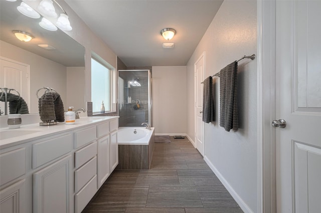 bathroom with a sink, double vanity, a bathtub, and tiled shower
