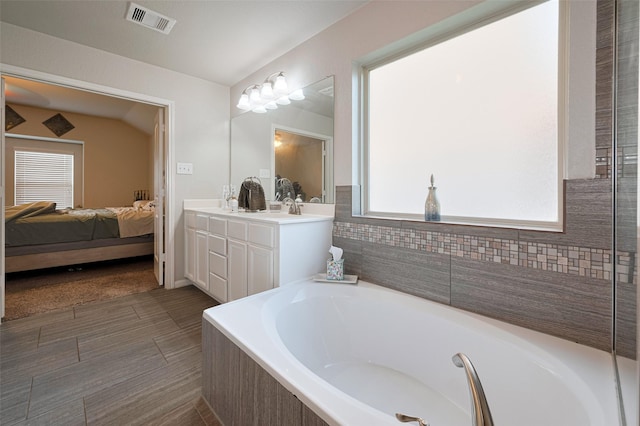 ensuite bathroom featuring connected bathroom, visible vents, plenty of natural light, and a bath