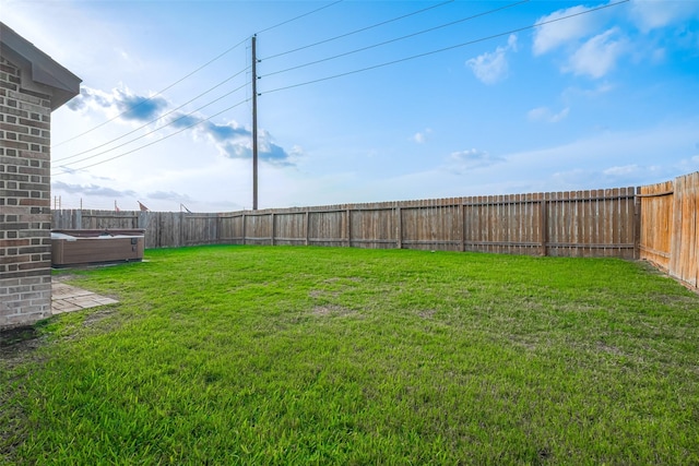 view of yard with a fenced backyard and a hot tub