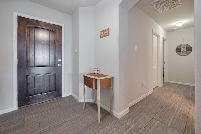 foyer entrance with visible vents, arched walkways, and baseboards
