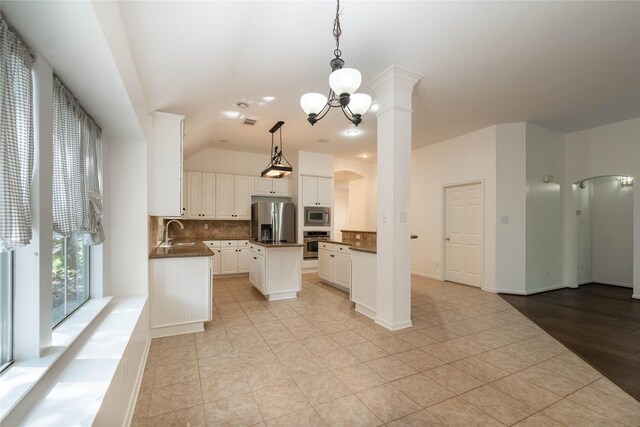54 N Crossed Birch Pl, The Woodlands, TX 77381 - kitchen featuring a sink, dark countertops, tasteful backsplash, arched walkways, and appliances with stainless steel finishes