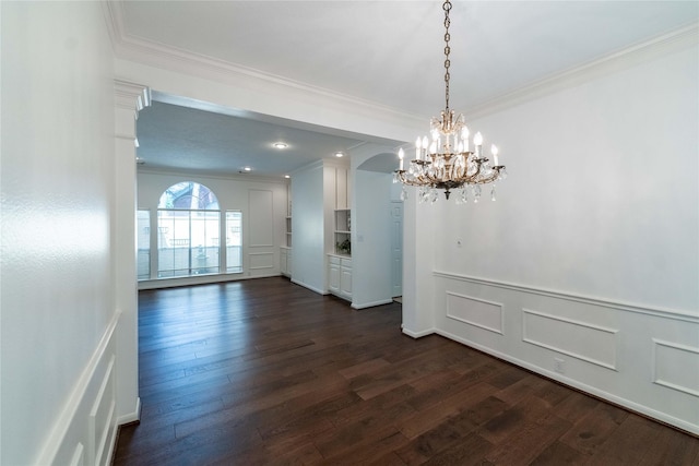 54 N Crossed Birch Pl, The Woodlands, TX 77381 - unfurnished dining area with crown molding, wainscoting, dark wood finished floors, an inviting chandelier, and a decorative wall