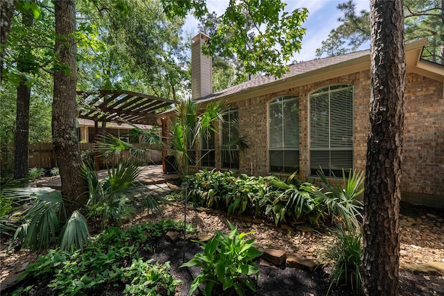 54 N Crossed Birch Pl, The Woodlands, TX 77381 - exterior space with brick siding, a pergola, fence, and a chimney