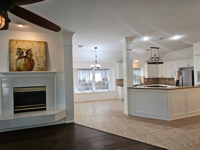 54 N Crossed Birch Pl, The Woodlands, TX 77381 - kitchen featuring tasteful backsplash, vaulted ceiling, stainless steel fridge with ice dispenser, open floor plan, and white cabinetry