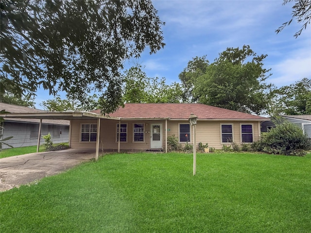 ranch-style home featuring concrete driveway, a front yard, and a carport