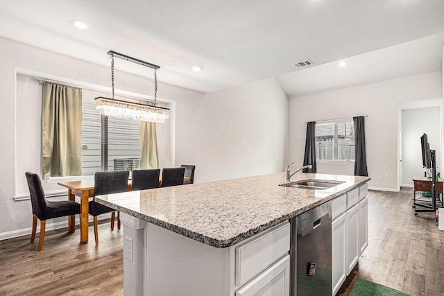 kitchen featuring white cabinets, dark wood-style flooring, a sink, dishwasher, and an island with sink