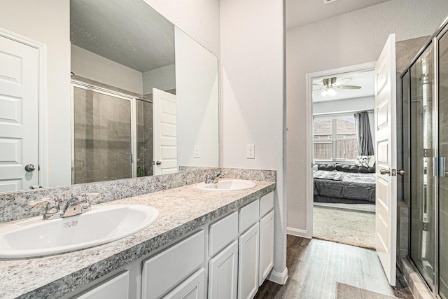 full bath featuring a sink, connected bathroom, wood finished floors, and a shower stall