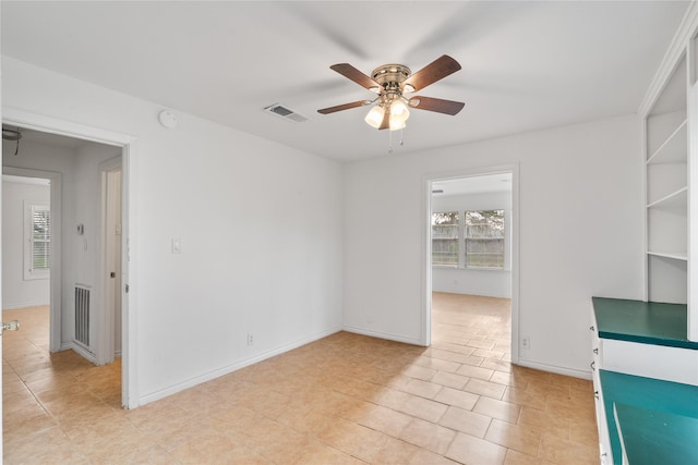 spare room featuring visible vents, baseboards, ceiling fan, and light tile patterned floors