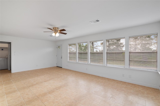 empty room featuring ceiling fan, visible vents, and baseboards