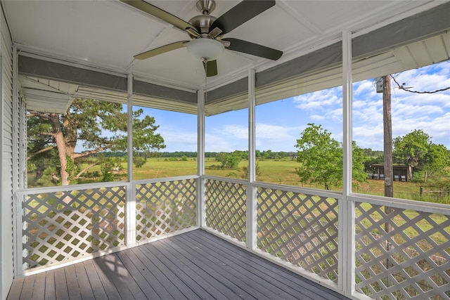 unfurnished sunroom featuring a ceiling fan