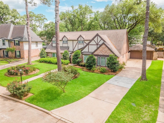 tudor-style house with stucco siding, brick siding, and a front lawn