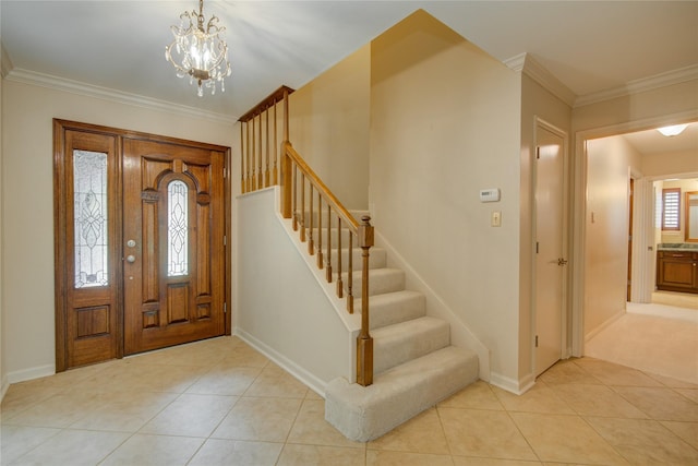foyer with crown molding, an inviting chandelier, baseboards, light tile patterned floors, and stairway