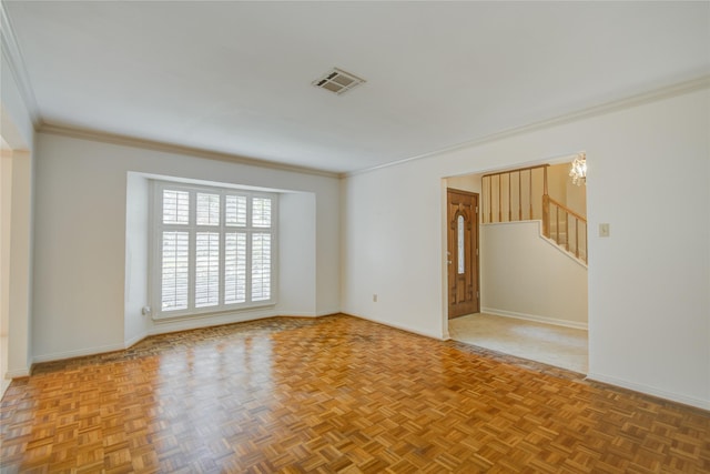 empty room with crown molding, baseboards, visible vents, and stairs