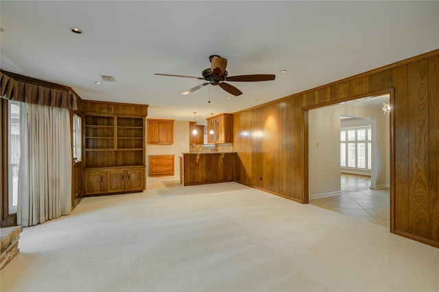 5311 Graystone Ln, Houston, TX 77069 - unfurnished living room featuring wooden walls, ceiling fan, light colored carpet, light tile patterned flooring, and baseboards
