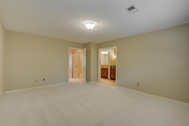 unfurnished bedroom with connected bathroom, light colored carpet, baseboards, and visible vents