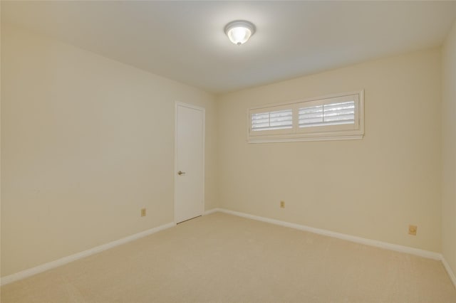 unfurnished room featuring light colored carpet and baseboards