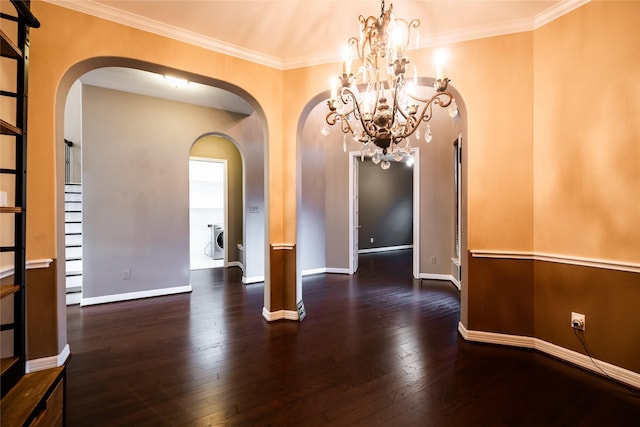 unfurnished dining area featuring washer / clothes dryer, arched walkways, an inviting chandelier, and hardwood / wood-style floors