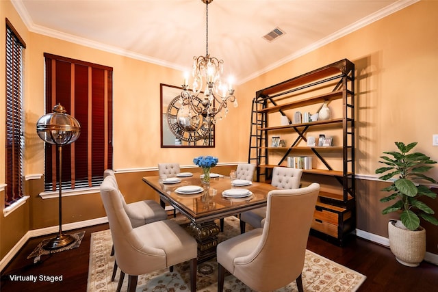 dining room featuring visible vents, ornamental molding, wood finished floors, and an inviting chandelier