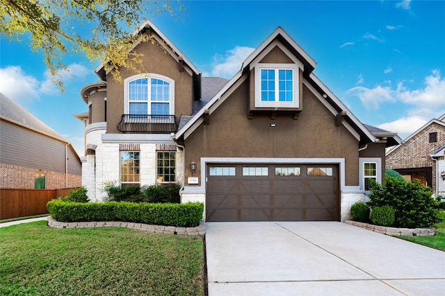 view of front facade with stucco siding, a front yard, stone siding, and concrete driveway