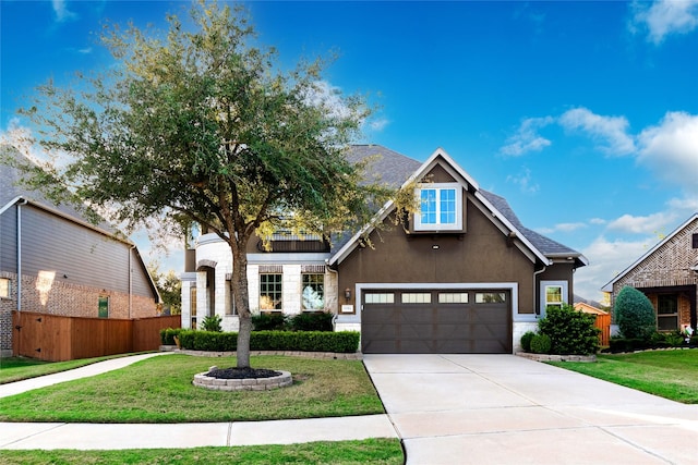 view of front of home with stucco siding, a garage, fence, and a front lawn