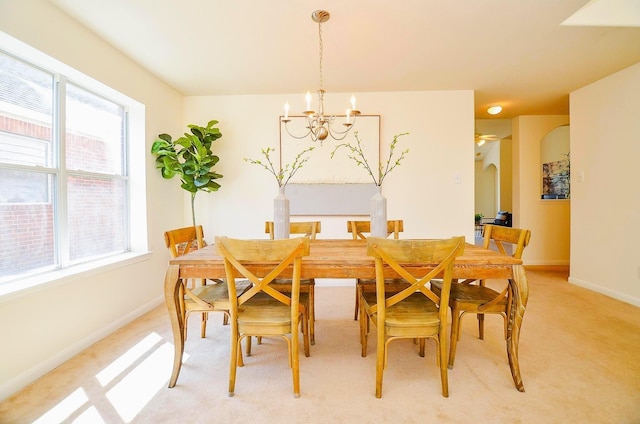 13216 Castlewind Ln, Pearland, TX 77584 - dining room with light colored carpet, arched walkways, a notable chandelier, and a wealth of natural light