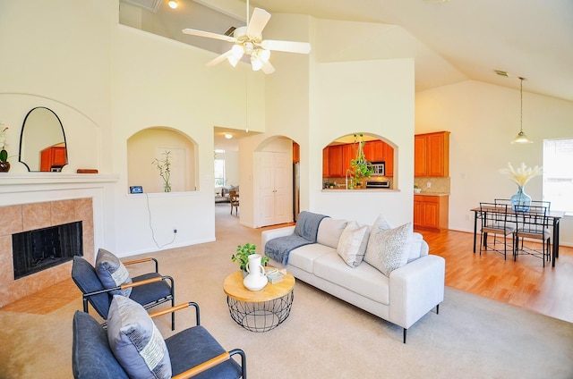 13216 Castlewind Ln, Pearland, TX 77584 - living room with high vaulted ceiling, a ceiling fan, a tile fireplace, and a wealth of natural light