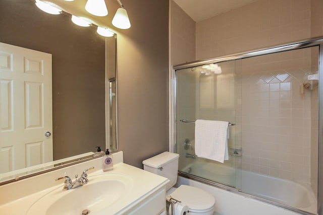 bathroom with vanity, toilet, and shower / bath combination with glass door