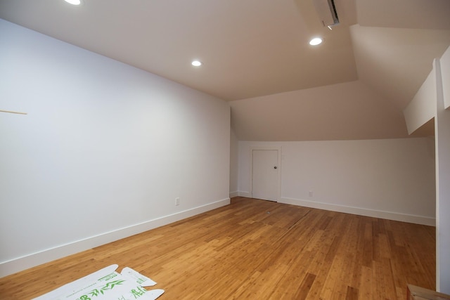 additional living space with recessed lighting, baseboards, vaulted ceiling, and light wood-type flooring