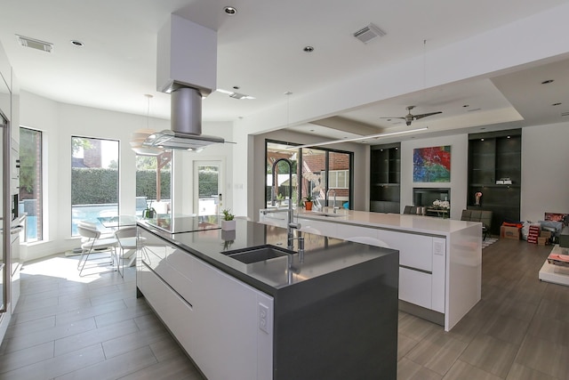 kitchen featuring a sink, modern cabinets, a large island, and visible vents