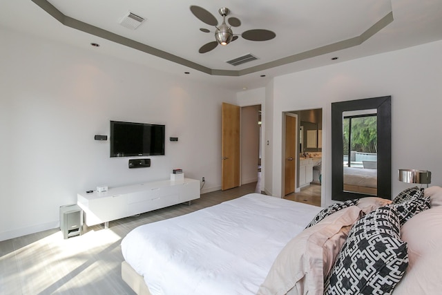 bedroom with visible vents, baseboards, and a tray ceiling