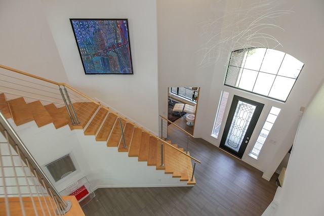 foyer with baseboards, stairway, and a towering ceiling