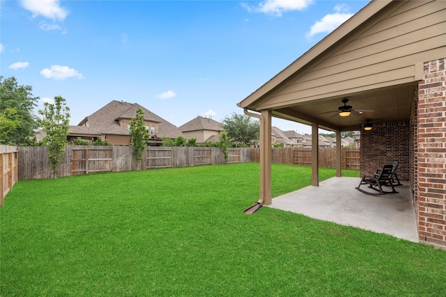 view of yard with a ceiling fan, a fenced backyard, and a patio area