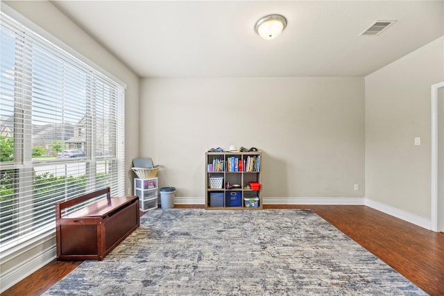 recreation room featuring visible vents, baseboards, and wood finished floors