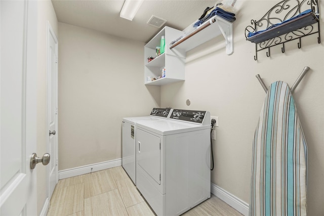 washroom with washer and dryer, laundry area, visible vents, and baseboards