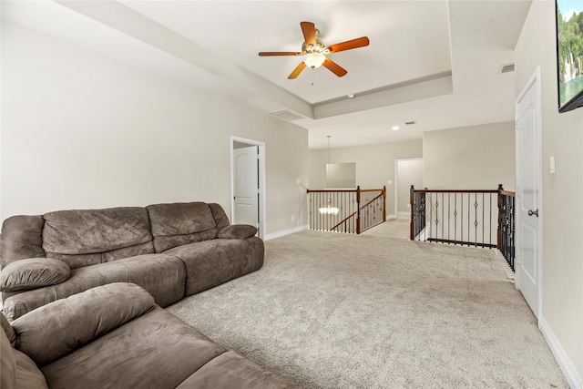 living room featuring baseboards, a ceiling fan, and carpet flooring
