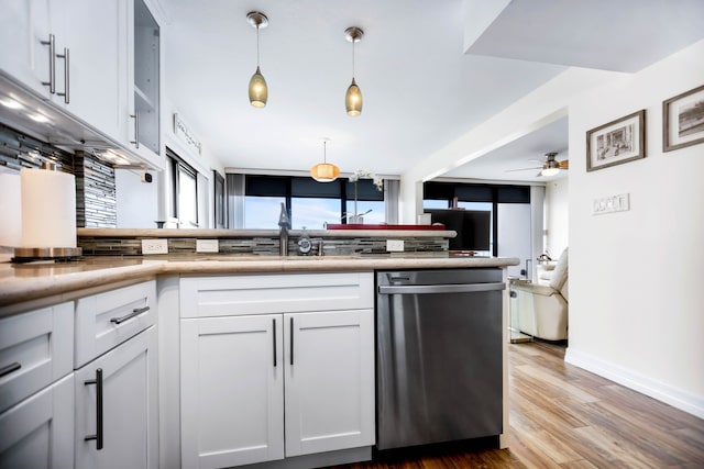 kitchen featuring a ceiling fan, pendant lighting, stainless steel dishwasher, light countertops, and white cabinetry