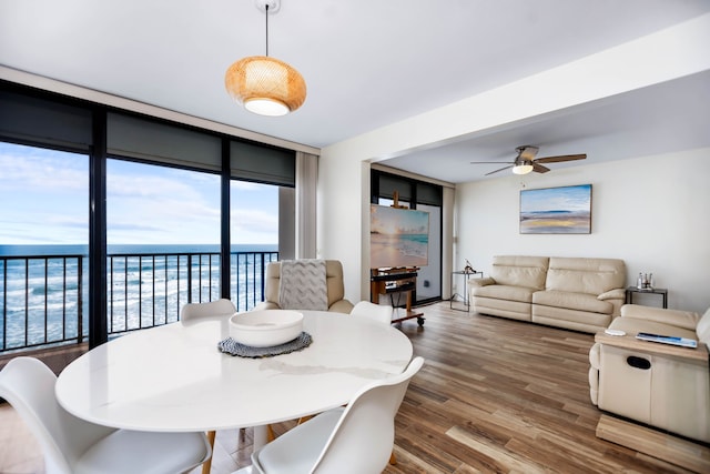 dining area featuring ceiling fan, expansive windows, and wood finished floors