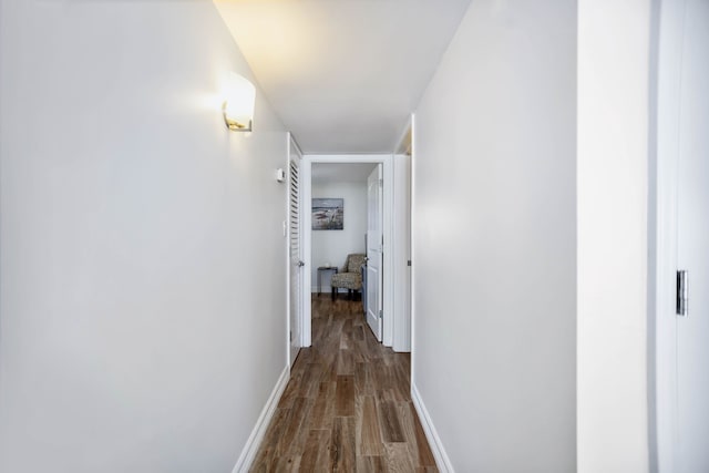 hallway with baseboards and dark wood-style flooring
