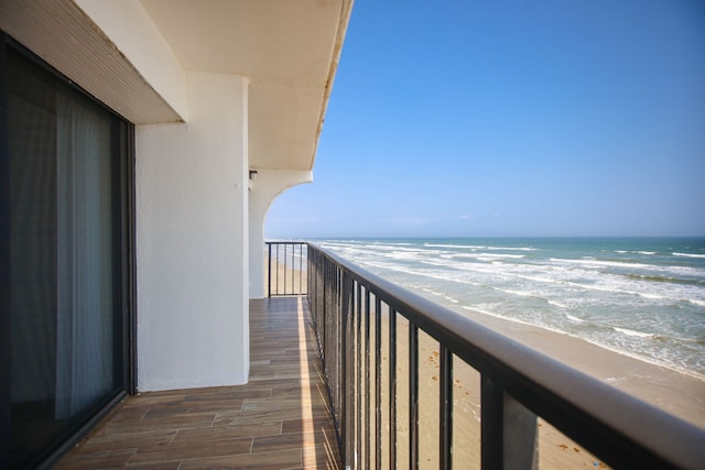 balcony featuring a water view and a view of the beach