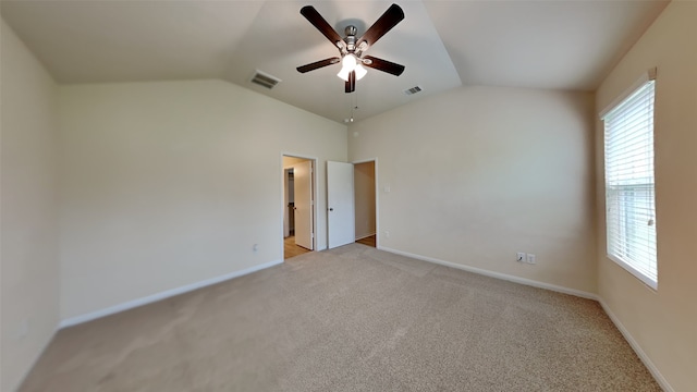 unfurnished room featuring vaulted ceiling, light colored carpet, and visible vents