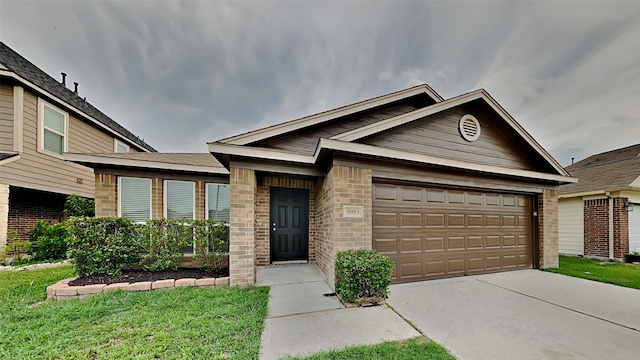 ranch-style house with a garage, concrete driveway, a front lawn, and brick siding
