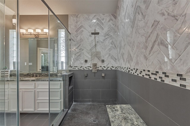 13625 Lakeside Place Dr, Willis, TX 77318 - bathroom with vanity, a tile shower, tile walls, and tile patterned floors
