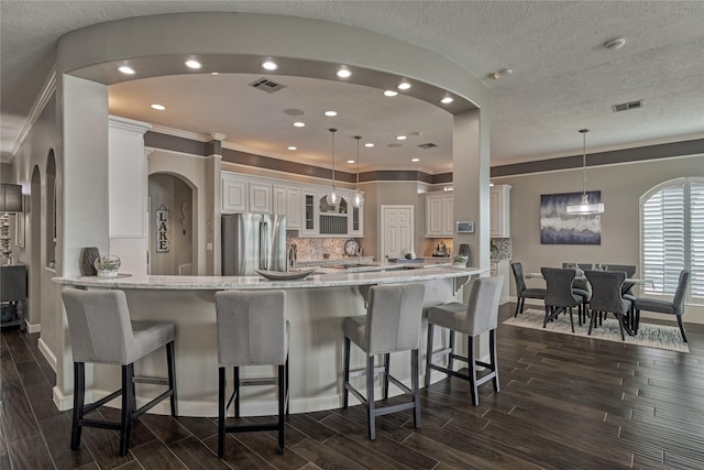 13625 Lakeside Place Dr, Willis, TX 77318 - kitchen featuring freestanding refrigerator, baseboards, glass insert cabinets, and visible vents